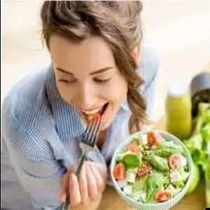 lady enjoying a bowl of vegan food tilting the bowl to show contents