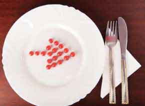 red berries on a white plate in the shape of a red arrow
