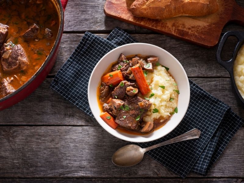 Beef Bourguignon Recipe with the red crock pot and a white bowl