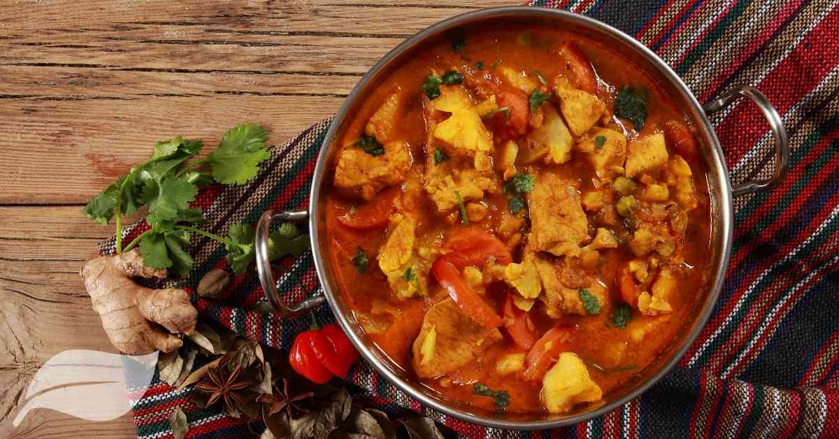 Easy chicken curry in a balti style dish with coriander leaves on the side