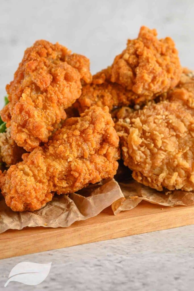 4 pieces of gluten free fried chicken on a wooden board
