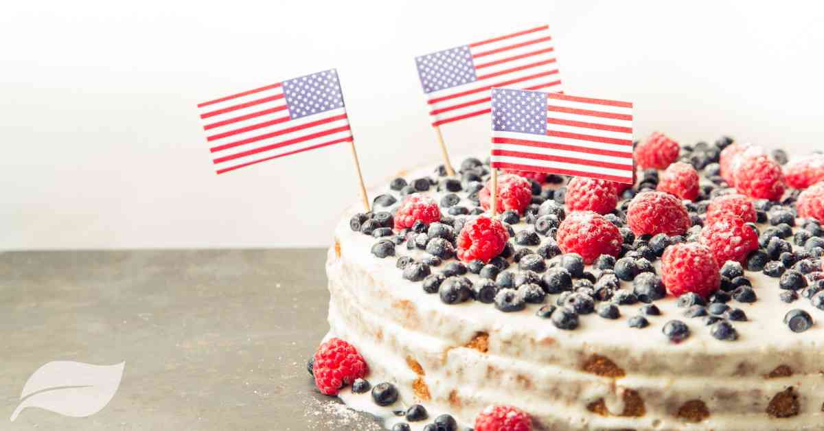 patriotic 4th july dessert in red, white and blue with american flags on cocktail sticks