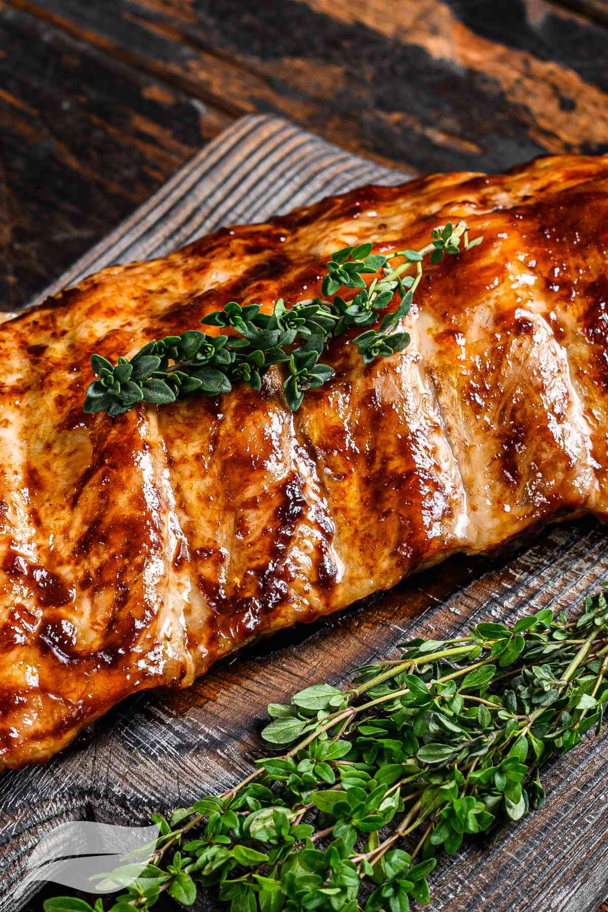 BBQ Ribs on a wooden board with fresh herbs