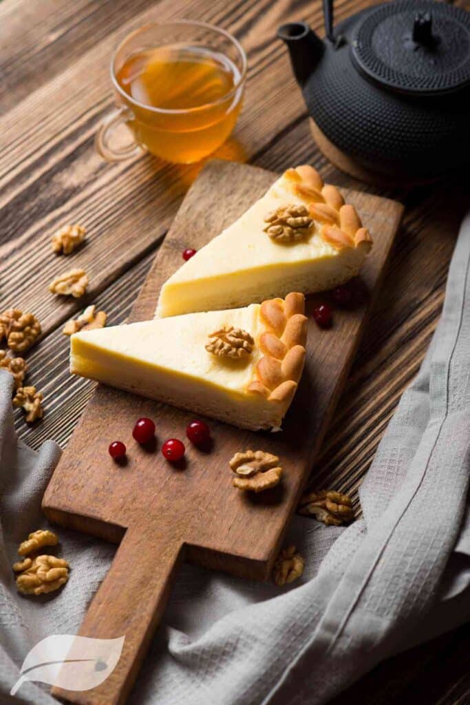 two pieces of cheesecake on a wooden board
