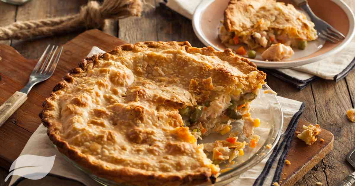 Chicken pie with diced vegetables and a piece of pie cut out
