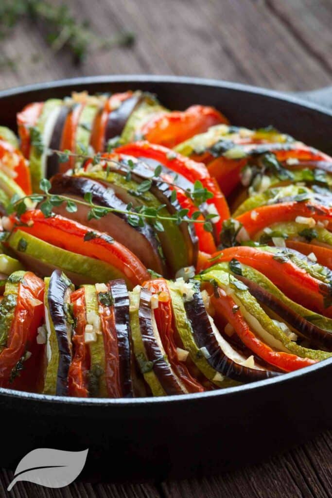 colored vegetables sliced and layed on end in a round casserole dish