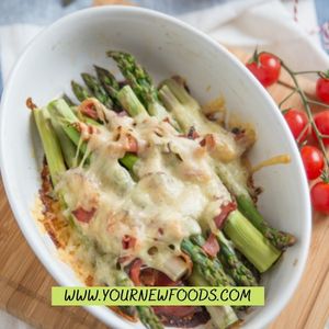 keto asparagus with melted cheese in a white oval bowl