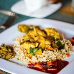 chicken curry on a white plate with rice