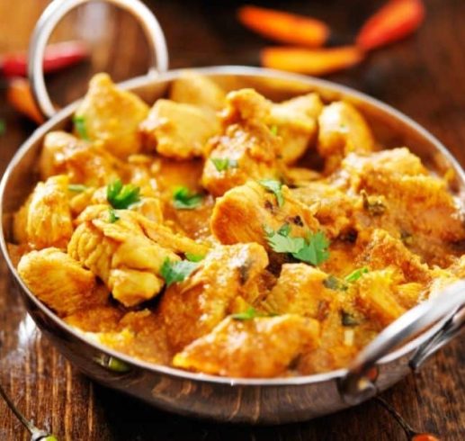 Chicken Curry Recipe in silver Balti style dishes with bowls of rice on a wooden table